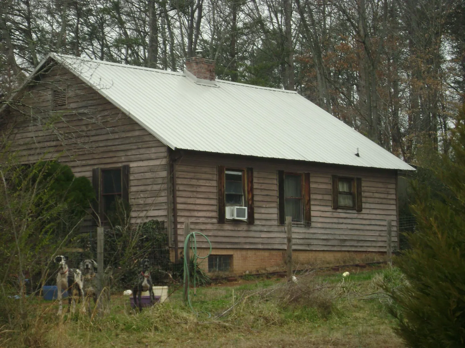 White metal roof on an old wood sided farmhouse, from a Metal Roof Installation job in Waterville